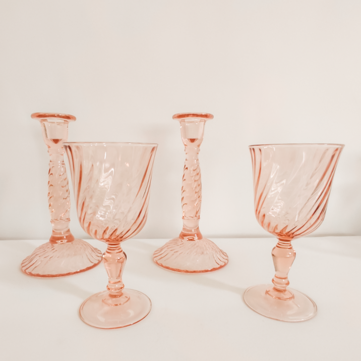Set of four pink vintage swirl glass goblets on a white background